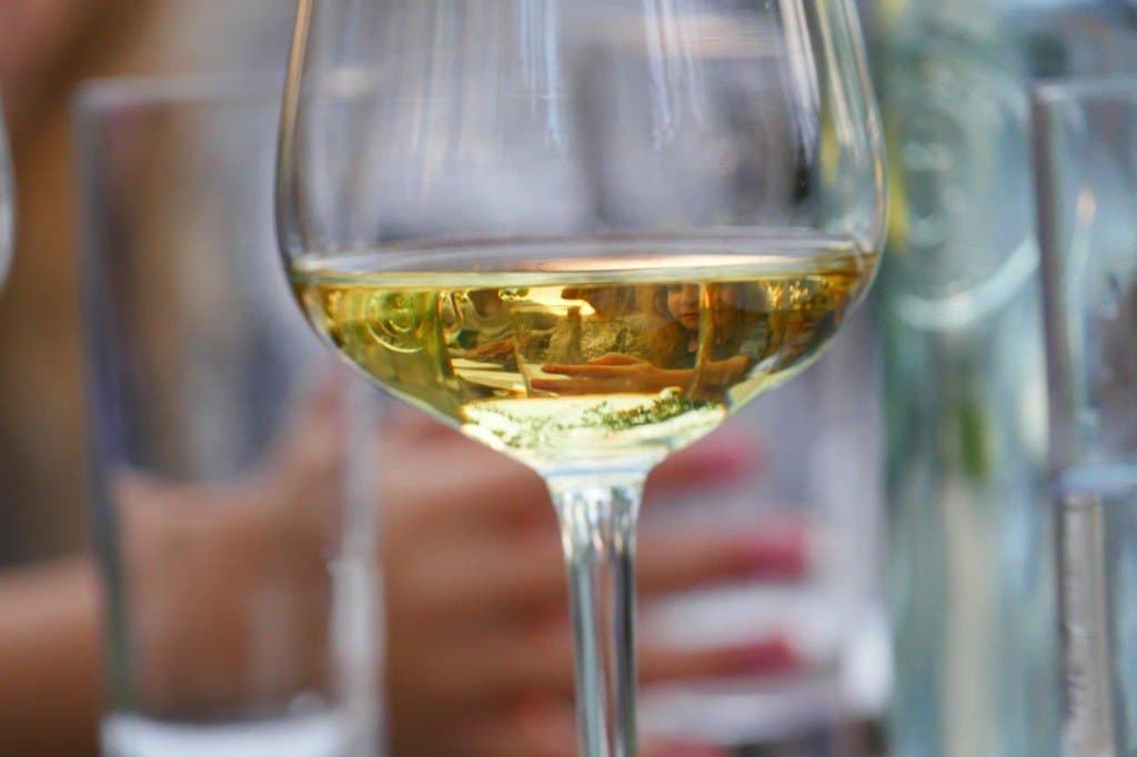 A glass of wine with a family reflected in the liquid